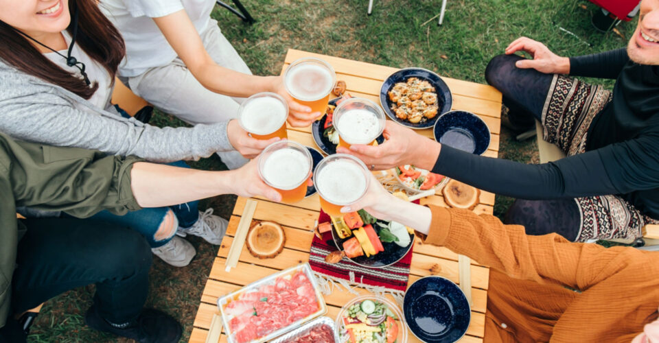 外で乾杯をする若い人たちの写真