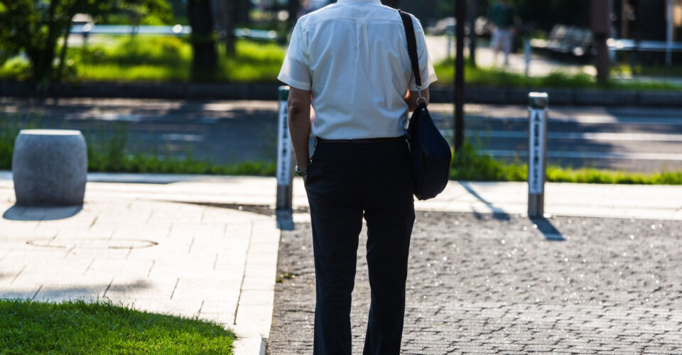 道の真ん中に佇むサラリーマン姿の男性の写真