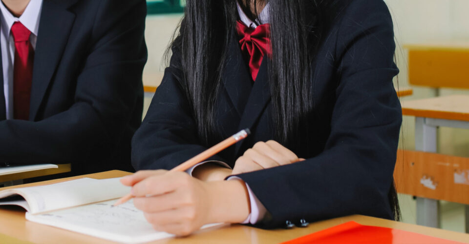 女子高生がノートに書き込んでいる写真