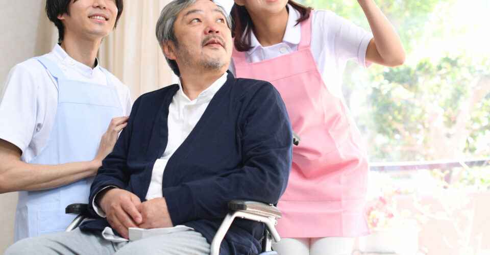 介護士と車椅子の男性の写真
