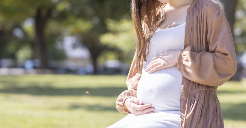 公園で座っている妊婦の写真