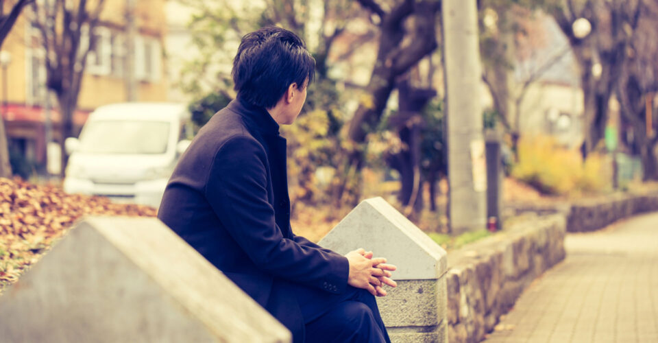 公園で黄昏れるサラリーマンの写真