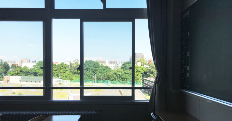 教室の中から見える晴れた校庭の写真